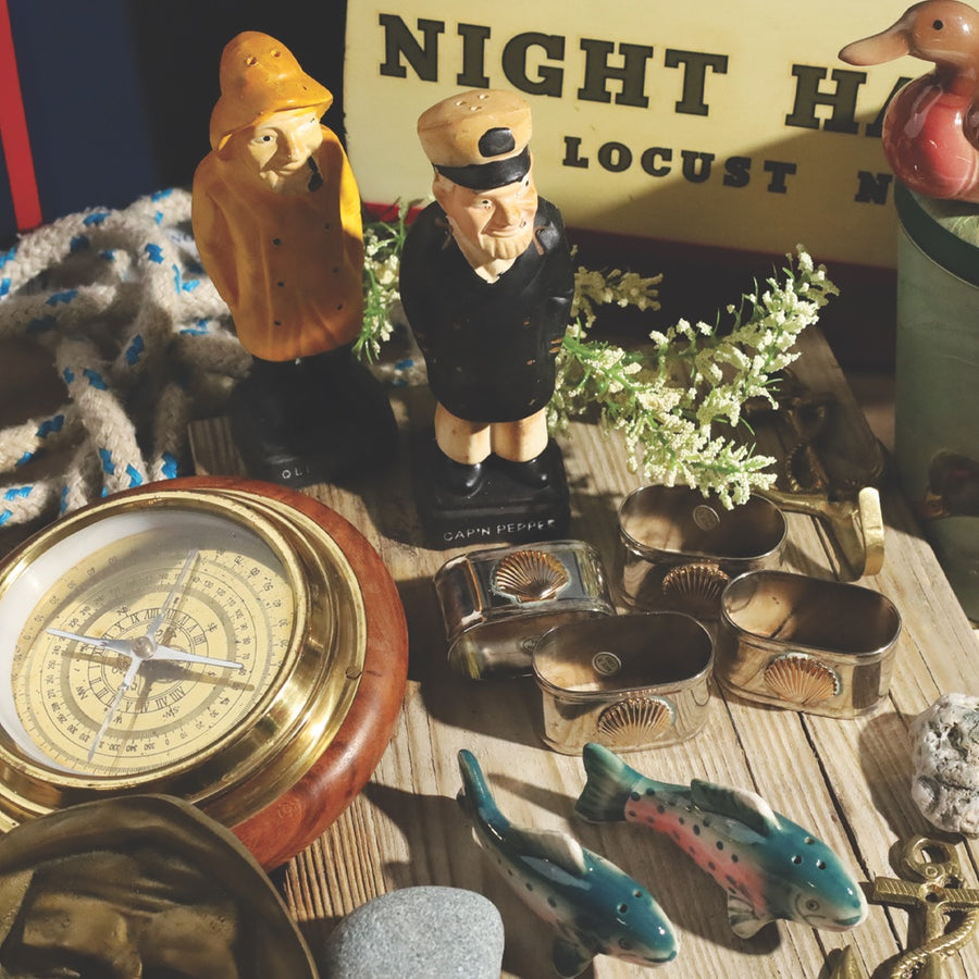 Vintage nautical figures, brass shell napkin rings and a wooden barometer